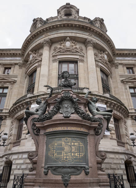 Paris, France - July 10, 2018: The magnificent Palais Garnier (Opéra Garnier) in Paris, France. The building's ornate façade, complete with Corinthian columns, golden statues, and intricate sculptures, is set against a bright blue sky.