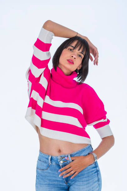 istock Latin woman dressed in a thread sweater which she models for the camera inside the photographic studio in which 2157366402