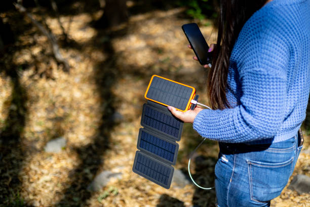 istock Woman using a portable solar panels on the go with her cellphone 2157368636