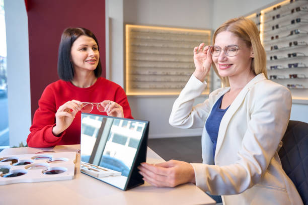 istock Smiling woman trying on glasses with stylish frames 2157371763