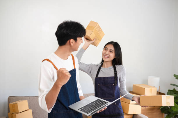 istock Happy Couple Running a Small Online Business from Home, Packing Boxes and Managing Order, E-commerce Entrepreneurs, Home Office Setup, Small Business Owners, Online Retail Success 2157374347