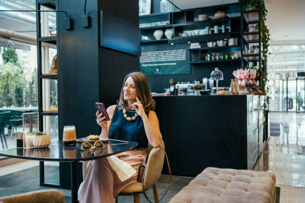 Businesswoman using cell phone in hotel cafe