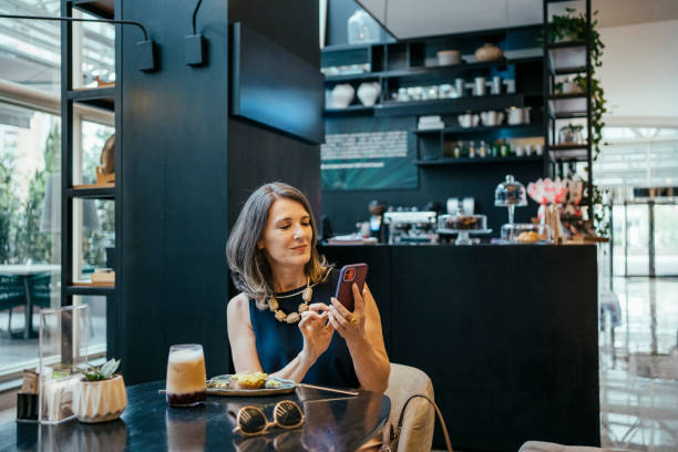 istock Businesswoman using cell phone in hotel cafe 2157374436