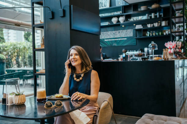 istock Businesswoman using cell phone in hotel cafe 2157374437