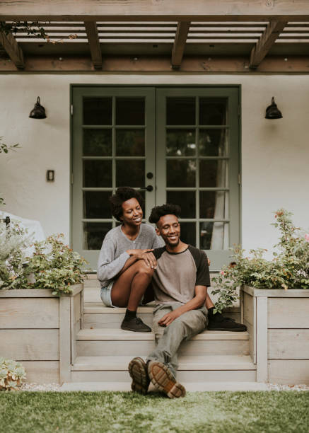 istock Cheerful black couple sitting on theri front porch 2157377237