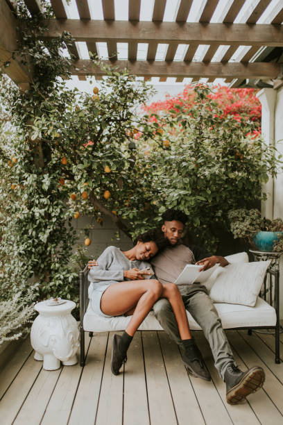 istock Black romantic couple chilling in the garden with a book 2157379445