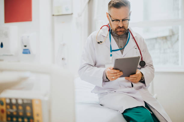 istock Serious doctor reading from a tablet 2157380063