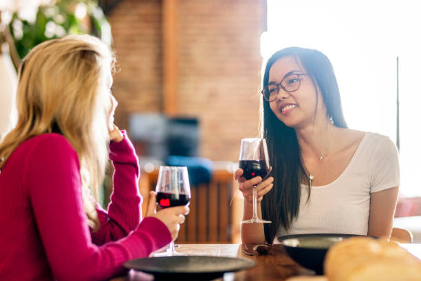 istock Female friends having red wine at a dinner party 2157380222