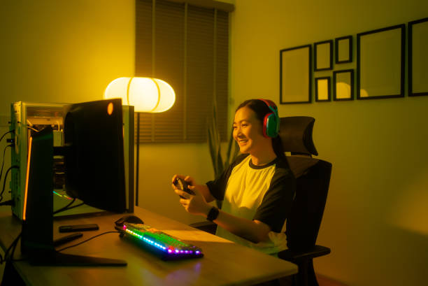 istock Asian woman happy enjoy using joystick playing computer game at home. 2157380693