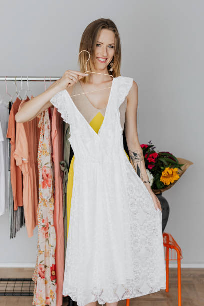 istock Woman trying a white dress on her 2157380784