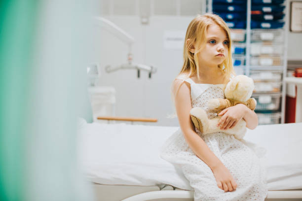 istock Young girl sitting alone on a hospital bed 2157381972