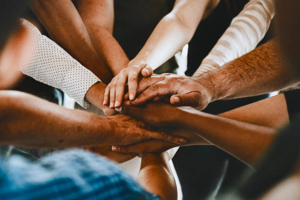 istock Group of diverse people stacking hands in the middle 2157382378