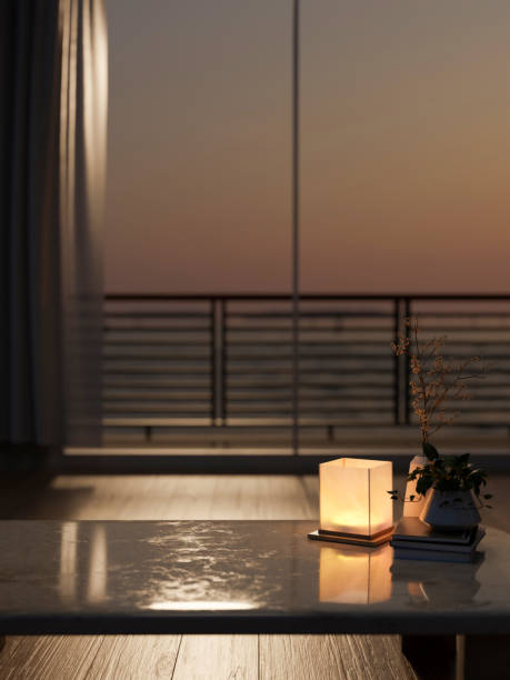 istock A coffee table in a contemporary living room features a dim light from a lamp and a sunset view. 2157383082