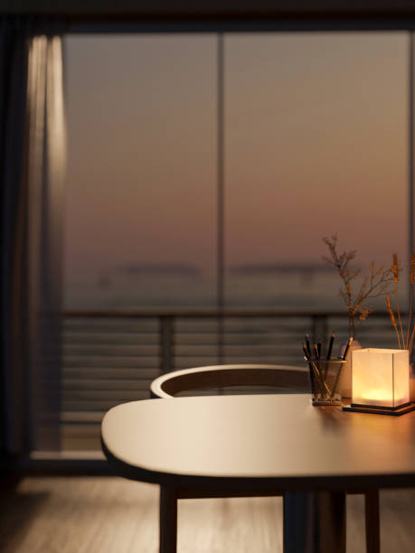 istock A wooden table in a modern room features dim light from a lamp and a sunset view through the balcony 2157383083