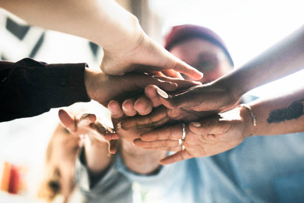 istock Happy team putting their hands together for success 2157383207