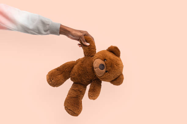 istock Teddy bear held by a hand for charity campaign 2157383281