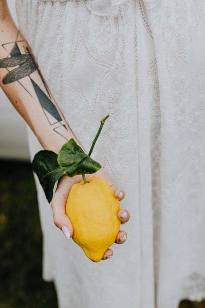 istock Tattooed arm holding a fresh lemon 2157383665