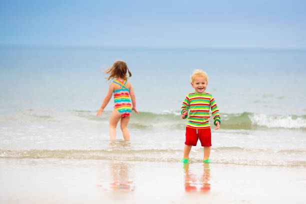 istock Kids playing on beach. Children play at sea. 2157384246