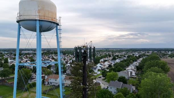 istock Wood Tree Look Cell Phone Tower Next To A Water Tower 2157386315