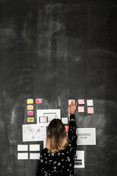 istock Leader in a startup company brainstorming using a blackboard 2157387525