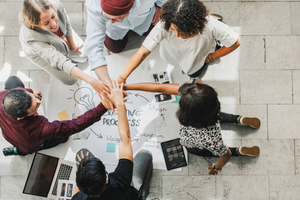 istock Happy team putting their hands together for success 2157387811