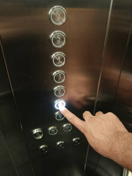 istock Male hand pressing button in elevator to go to floor 2157388013