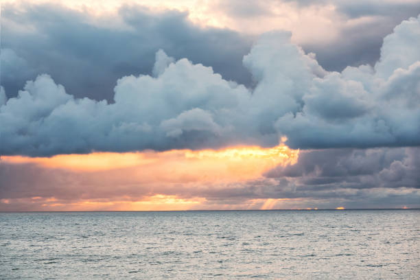 istock Dramatic evening sky over the sea. Rays of the setting sun break through rain clouds. Background. Landscape. 2157390456