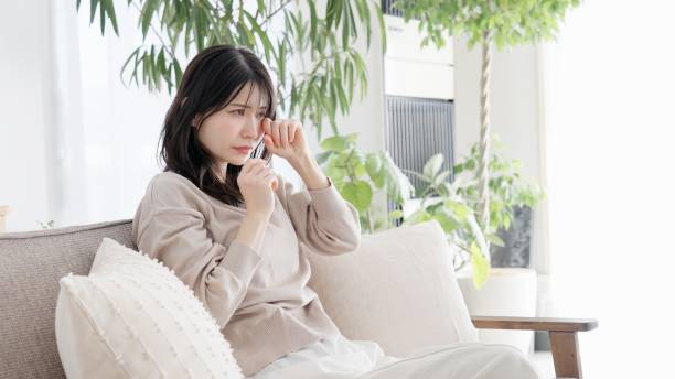 居間で泣いている女性 - パニック障害 日本人 ストックフォトと画像