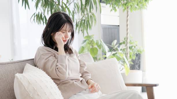 woman crying in the living room - うつ病 日本人 ストックフォトと画像