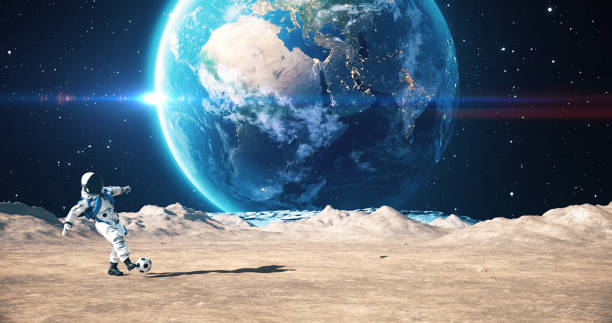 Astronaut On An Alien Planet Playing Soccer. Planet Earth Is Visible. Space Related Majestic Scene.\n\nWorld Map Credits To NASA : https://visibleearth.nasa.gov/images/57752/blue-marble-land-surface-shallow-water-and-shaded-topography