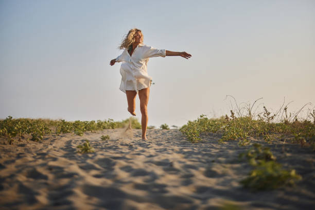 istock Young carefree woman running on the beach. 2157393843