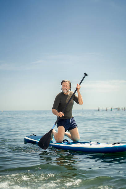 istock Mature man paddle boarding in the sea 2157394480