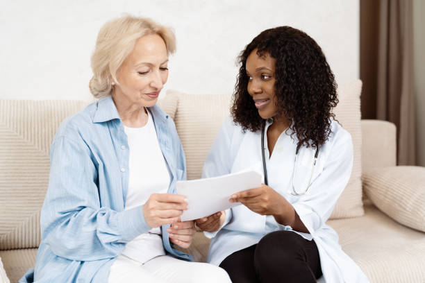 istock Doctor Consulting Elderly Patient in Living Room Setting 2157397599