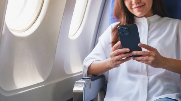 istock Closeup image of a woman holding and using mobile phone while traveling on an airplane 2157398067