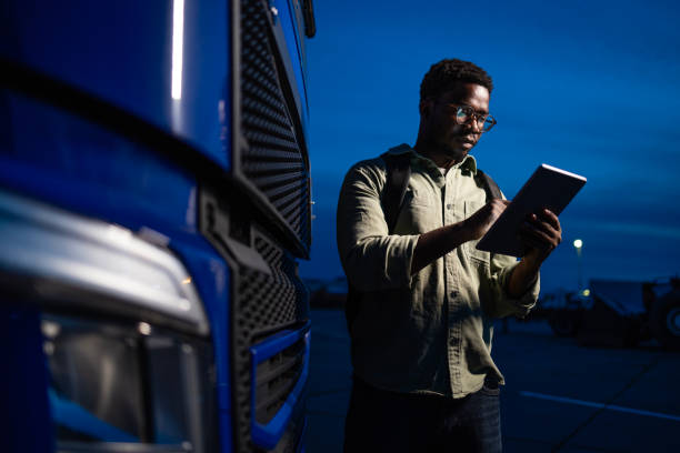 istock Experienced truck driver checking navigation equipment and preparing for night transport. 2157399429