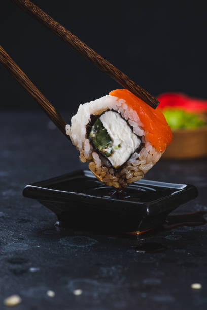 istock The roll is held with chopsticks and dipped in soy sauce 2157401305