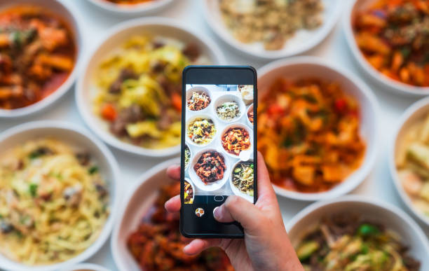 istock Hand holding mobile phone above Brunch table set up. 2157401673
