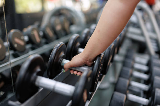 istock Closeup of hand picking a dumbbell 2157401961
