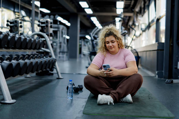 istock Relaxed Woman Sitting on Mat with Phone 2157402074