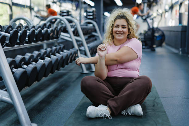 istock Woman sits on mat preparing for workout 2157402188