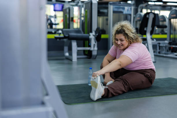 istock Smiling woman performing a stretch at gym 2157402252