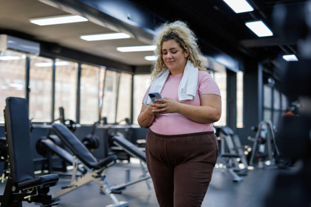 istock Focused Woman Checking Phone at the Gym 2157402411