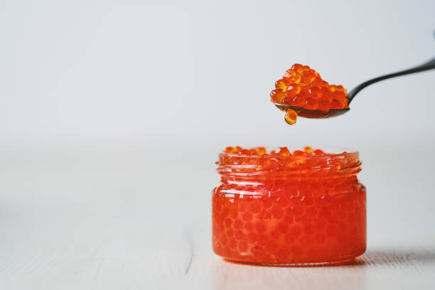 istock Open jar with red caviar and a spoon above it 2157402908