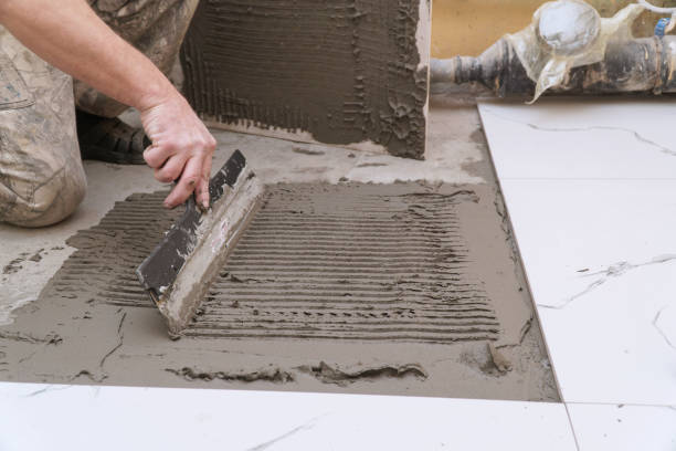 istock A construction worker applies cement for laying floor ceramic tiles with special spatula 2157402968