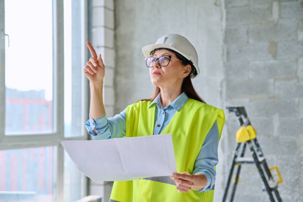 istock Technical profession woman in protective vest helmet working on construction 2157406655