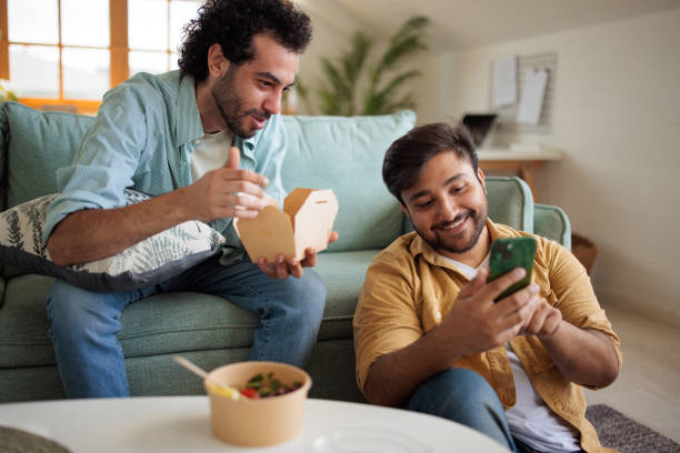 istock Two friends eating and talking at home 2157407604