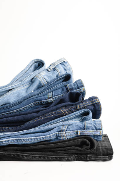 istock A stack of folded jeans in various shades of blue and black on a white background 2157408575