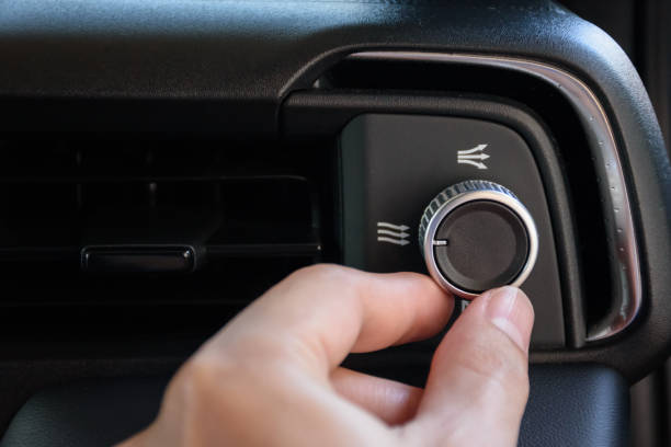 istock Hand turning the air conditioning control button inside the car for changing the air conditioning mode in a luxury and modern car, year 2024. 2157408743