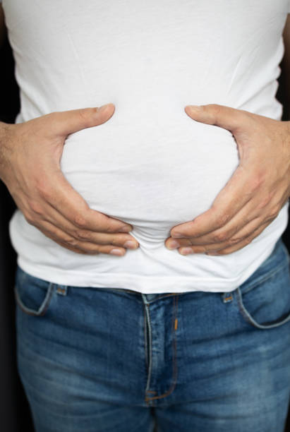 istock Man in t-shirt touching his stomach 2157409282