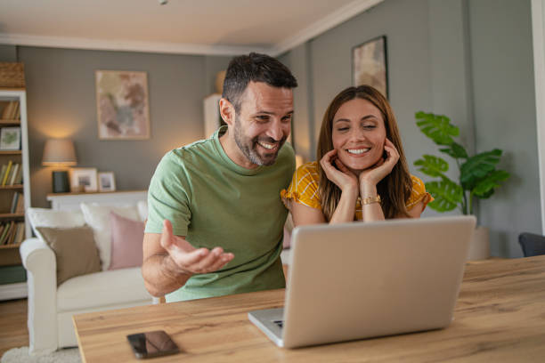 istock Couple at home making a reservation online using their laptop 2157409766